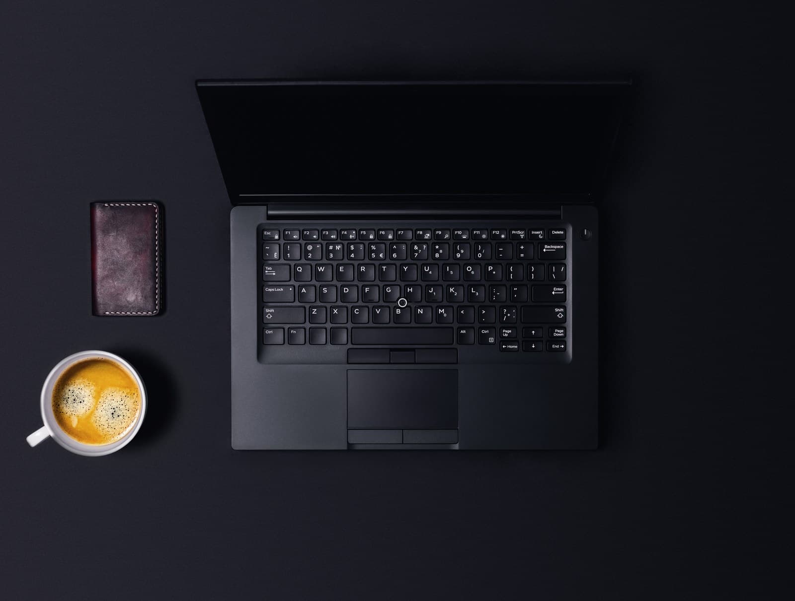 Laptop and coffee on a dark desk